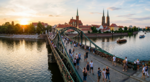 A professional, high-angle editorial photograph of the picturesque Tumski Bridge in Wrocław during t