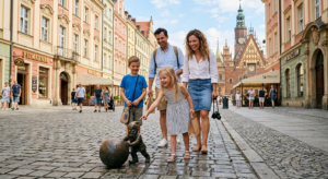 A bright, editorial-style photograph of a happy family exploring a cobblestone street in Wrocław’s O
